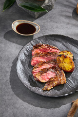 Bavette steak alternative cut with roasted potato, bright lighting, minimal overhead composition