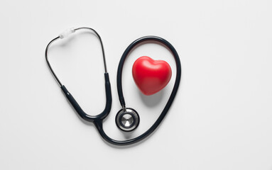 top view, Red heart shape exercise ball with doctor physician's stethoscope on white background. hospital life insurance concept, world heart health day. doctor day