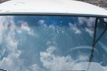 A car with a broken windshield on a sunny day. 