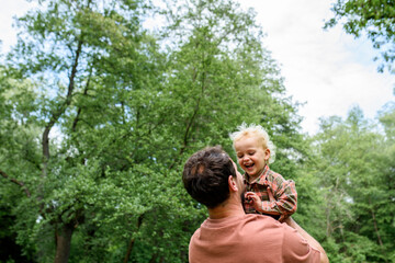 Portrait of dad hugging little son, enjoying time together