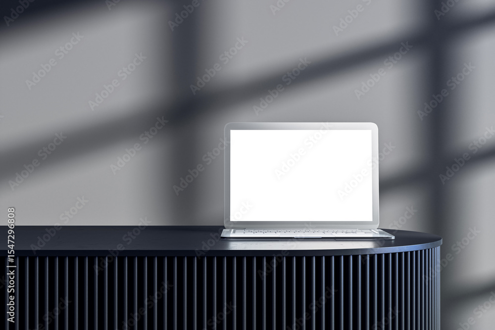 Aufkleber Laptop with blank screen placed on dark modern podium in stylish interior studio with soft shadow light pattern on background wall. 3D Rendering