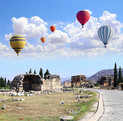 Air balloons and ancient building on Frontinus street, Hierapolis, Pamukkale, Turkey. Topic of...