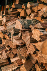 Close-up of stacked chopped firewood with visible texture, bark, and natural grain patterns in warm tones