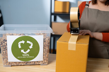 A woman using kraft paper tape to seal a cardboard box in a home-based business, highlighting eco-friendly packaging and sustainable practices in small business operations
