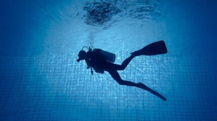 A scuba diver explores underwater in a tranquil pool setting.