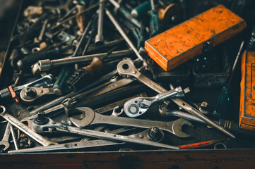A close-up of an assorted collection of metal hand tools, including wrenches and ratchets, arranged...