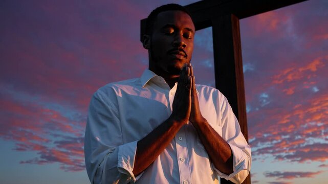 Man praying before a cross at sunset, symbolizing Christian devotion, hope, repentance, faith in God, and the personal relationship with Jesus through heartfelt worship and surrender