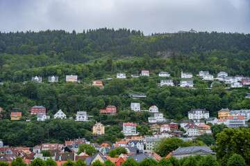 Bergen, Norway. Scenic view of vibrant homes nestled into the forested hills, typical residential...