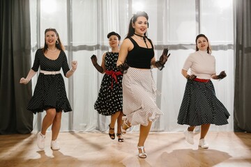 Naklejka premium Four pinup dancers wearing polka dots are performing a choreography
