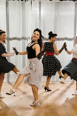 Pinup dancers wearing polka dots swing dancing in studio