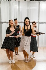 Four pinup dancers wearing polka dots swinging in dance studio