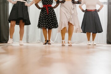 Four women wearing fifties style polka dot dresses and posing for a dance performance