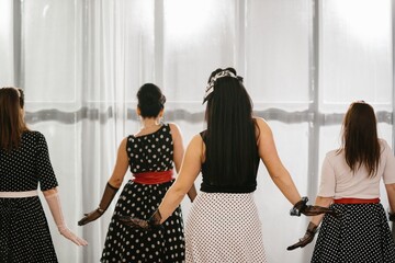 Four pinup dancers wearing polka dots showing choreography