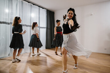 Pinup dancers wearing polka dots swinging in dance studio