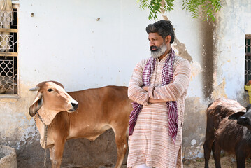 Rural Indian farmer caring with farm cattle animal at village area