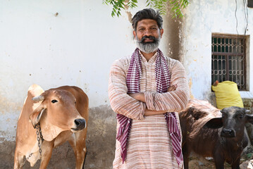 Rural Indian farmer caring with farm cattle animal at village area © Pix4Ads