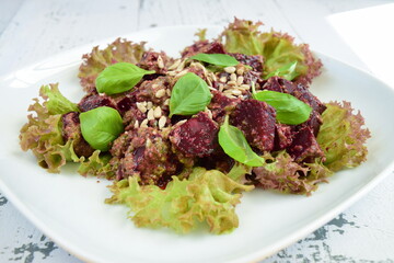 Beetroot salad with pesto sauce on lettuce garnish with sunflower seeds