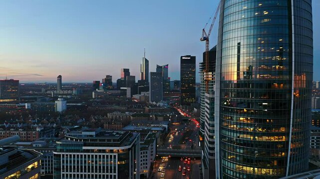 Aerial view of modern cityscape at dusk showcasing illuminated skyscrapers and evening traffic movement