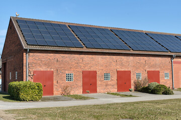 Traditional German barn with repeating solar panels in Lower Saxony countryside © VeugerStock