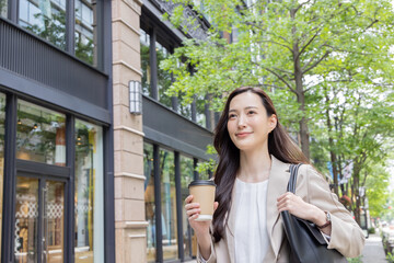 コーヒーをテイクアウトするビジネスウーマン