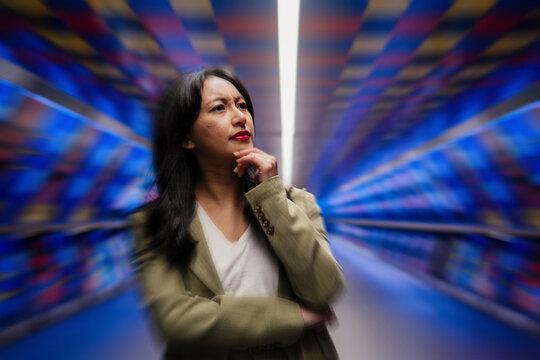 Woman contemplating in a dynamic, colorful setting with a focus on big data and technology