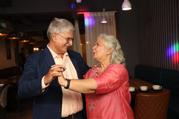 Active seniors spending quality time at cafe. 
Indian happy elderly old senior couple grandparents...