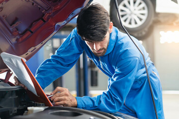 Auto check up and car service shop concept. Mechanic writing job checklist to clipboard to estimate...