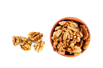 Heap of walnuts in clay bowl isolated on white background.