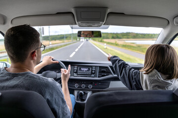 Straight road. Highway journey. Driver and child.