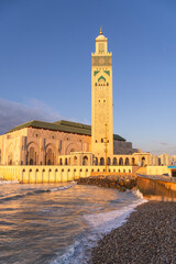 Casablanca, Morocco: Sunset over the famous Hassan II mosque and minaret by the Atlantic ocean in...