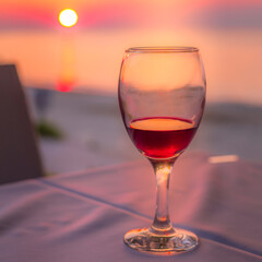 Romantic glass of wine on the beach at sunset