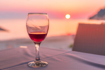 Romantic glass of wine on the beach at sunset