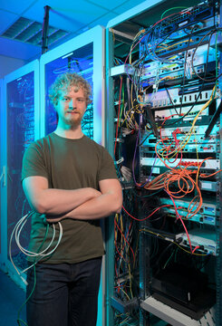 Network engineer in a server room with cables and server racks