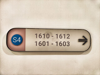 Directional sign guiding visitors to room numbers 1601 through 1612 in a commercial building,...