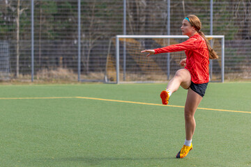 Sporty girl scores a goal into the goal. Football concept. Girl on the football field.