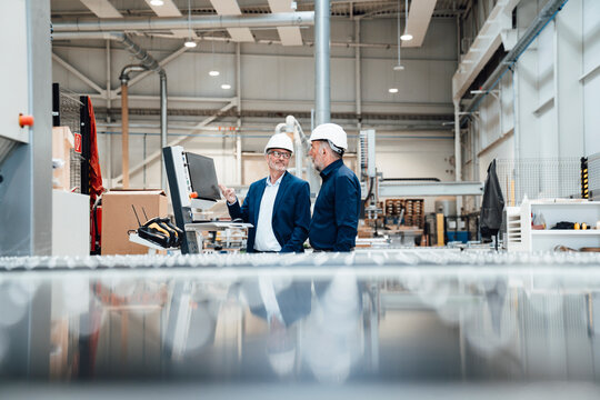 Engineers discussing plans in a modern factory setting