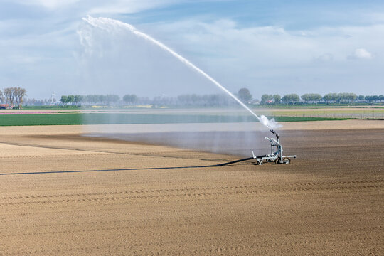 Waterkanon spuit water over droge akker, door klimaatverandering valt er vaker te weinig regenwater op het land