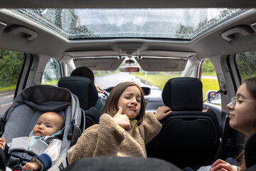 Family car trip. Happy child in backseat. Baby in car seat.