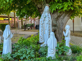 A figure of Mary and the children of Fatima (Jacenta, Lucia, and Frances) in the garden at the...