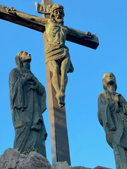 The Lord Jesus on the cross and two women under the cross in the garden at the Minor Basilica of Our Lady of Listening Patiently in Rokitno, Poland