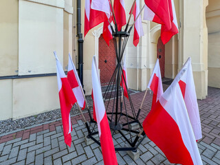 Polish flags in a stand in front of a building