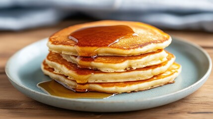 Stack of golden pancakes drizzled with syrup