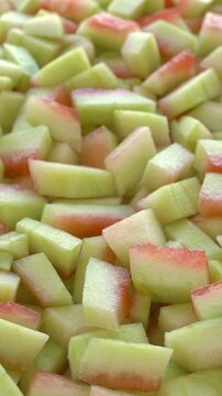 Peeled watermelon rind chunks background texture. Watermelon rind is edible after heat treatment (stir-fry, braise, or cook). Zero waste food concept. Selective focus, table spin, vertical video.