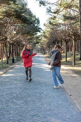 Two women walking in the park. Friends walking on a path in the park. Nature.