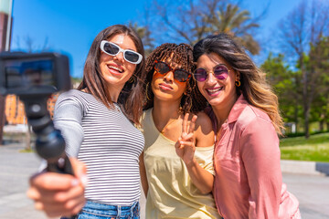 Happy friends taking selfie with action camera during summer vacation