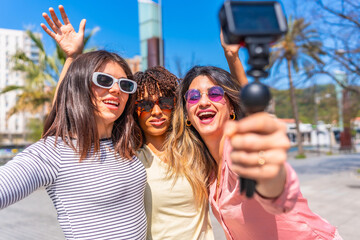Happy friends vlogging their summer city trip with action camera