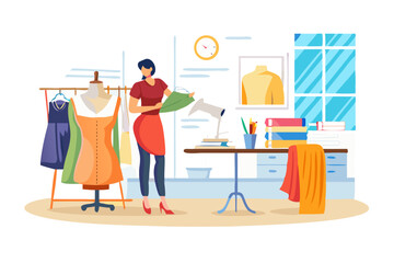 Fashion designer working in her studio with dresses and fabrics
