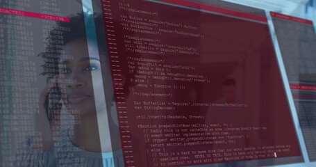 Analyzing developer holding smartphone and gazing at red-tinted code on transparent panel in office
