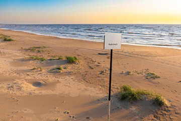 nude beach sign with blue sky