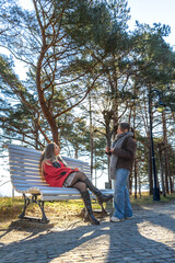 Two women sitting on a park bench. Park. Two women spending time together.